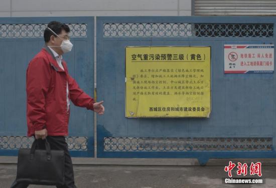 10月19日，北京市民戴口罩从一处施工现场外悬挂的“空气重污染预警三级”公告牌前经过。当日，中国环境监测总站发布的全国空气质量预报信息显示，京津冀地区出现大范围空气污染天气，其中北京、天津、石家庄、唐山、保定重度污染。监测显示，10月19日6时，北京、天津、石家庄、唐山、保定、东营、滨州出现重度空气污染，首要污染物为PM2.5。 <a target='_blank' href='http://www.chinanews.com/' _fcksavedurl='http://www.chinanews.com/'></table>中新社</a>记者 刘关关 摄