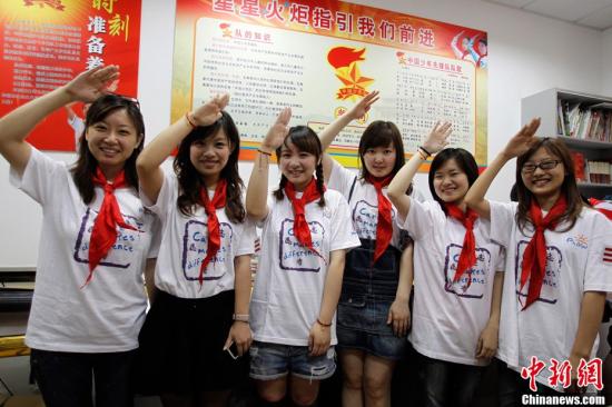 资料图 6月1日，上海一群外企女白领回到校园，带上红领巾重温儿童节。时下，上海成年人流行玩童年游戏、吃童年零食，以舒缓压力。红领巾、海魂衫、三道杠成为这几天最为热销的节日商品。汤彦俊 摄