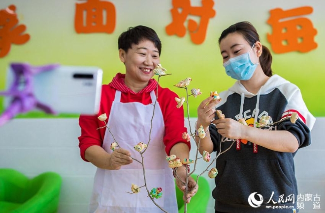 呼和浩特市玉泉区通顺街小学老师在直播中展示面塑“寒燕儿”的制作技艺。
