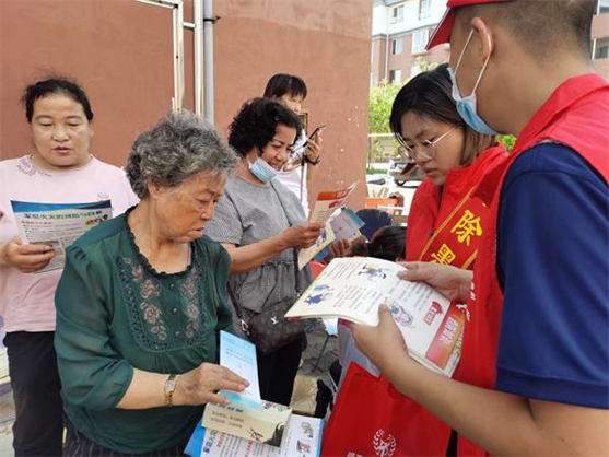 政法委志愿者向居民发放反邪教资料和宣传品